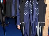 beaucoup de vêtements suspendus à une étagère dans une pièce