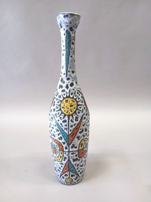 un vase blanc avec un motif sur une table