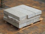 a stack of concrete blocks on a pallet on the sidewalk