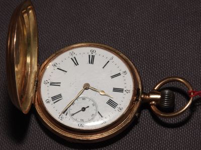 une montre de poche en or avec des chiffres romains