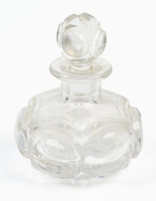 une bouteille en verre transparent ornée d'une fleur sur le goulot