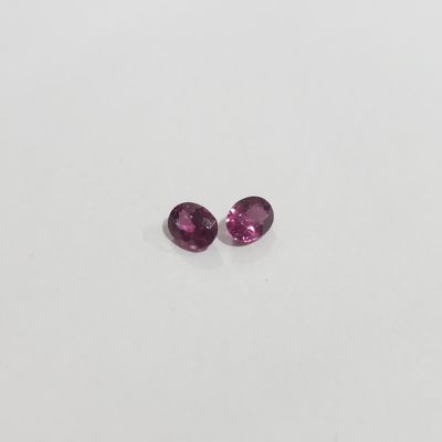 a pair of pink tourmaline gems on a white surface