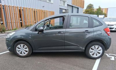 une petite voiture grise garée sur un parking
