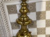 a brass faucet on a tiled wall in a bathroom