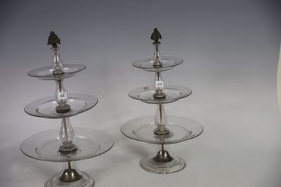 three tiered glass plates with silver decorations on them