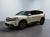 Le SUV blanc est garé dans une pièce au sol gris.