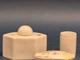 une petite boîte blanche avec un couvercle et un petit récipient orné d'une fleur