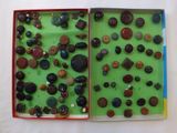 an open book with a bunch of buttons in it on a white surface