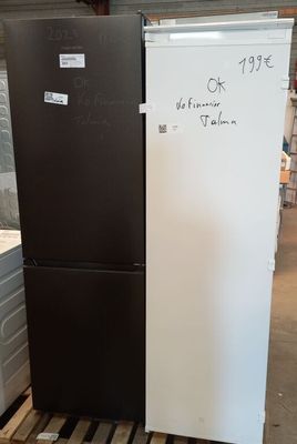 two black and white refrigerators sitting in a warehouse next to each other