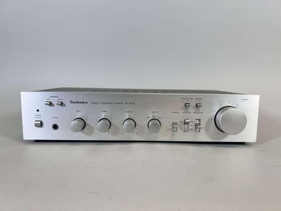 a close up of a silver amplifier on a white surface