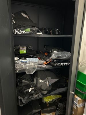 une armoire remplie de vêtements et d'autres objets dans la pièce