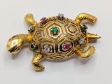 an image of a gold turtle brooch with multi colored stones