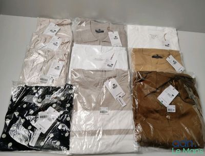 several men ' s shirts are wrapped in plastic bags on a table