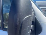 an image of a side view mirror of a white van