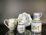 trois tasses et une théière posées sur une table