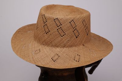 un chapeau de paille posé sur un vase