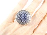 someone is holding a ring with blue and white diamonds on it