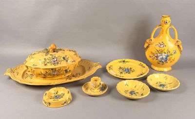 a yellow table setting with a vase, bowl, plate, and cups