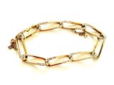 gros plan d'un bracelet en or sur fond blanc