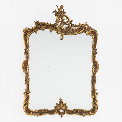 un miroir à cadre doré orné d'un motif décoratif