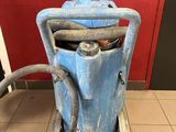 a blue dust collector sitting on the floor in front of a red wall