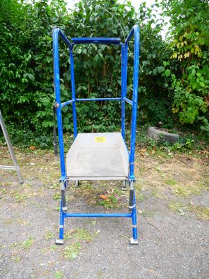 a blue metal chair sitting in the middle of a parking lot