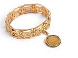 bracelet en or avec une pièce sur fond blanc