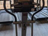 two tread machines in the gym with a view of the trees outside
