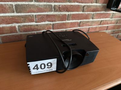 une photo montrant un petit projecteur posé sur une table en bois