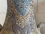 a vase that is sitting on a table in front of a brick wall