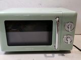 a small green microwave sitting on a counter top