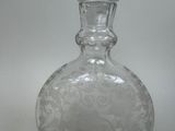 a clear glass bottle with a design on it