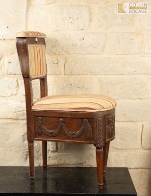 une chaise en bois avec une assise rayée, posée près d'une table noire