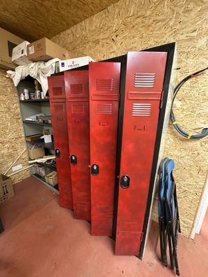 trois casiers rouges dans une pièce où se trouve une chaise dans un coin