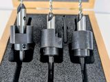 four pieces of drill bit set in a wooden box on a table