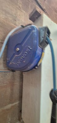 un tuyau bleu fixé au mur, à côté d'un mur de briques