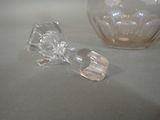 a clear glass object on the table next to a glass bowl