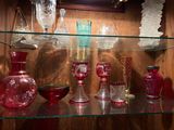 de nombreux vases en verre posés sur une étagère en verre dans une vitrine