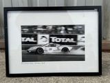 black and white photograph of a racing car in a race track