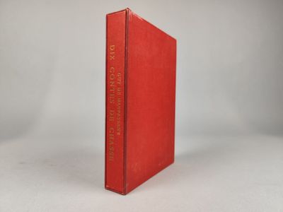 un vieux livre rouge posé sur une table à côté d'un mur blanc