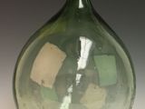 un vase en verre vert posé sur une table blanche