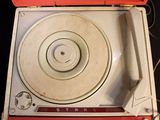 a record player sitting on top of a red case