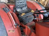 a red tractor that is parked in a garage