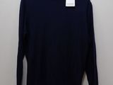 a black sweater hanging on a hanger in front of a white wall