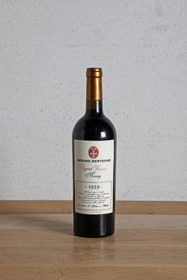 une bouteille de vin rouge posée sur une table en bois