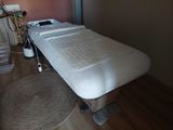 a massage table with a mattress on it in a room