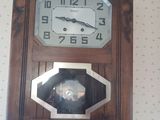 une horloge en bois accrochée au mur d'une pièce
