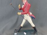 figurine représentant un homme vêtu d'une veste rouge et d'un pantalon blanc, tenant une canne