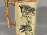 a ceramic mug with birds on it on a table