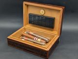 two cigars in a wooden box on a table